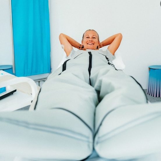 Frau genießt eine Spa-Behandlung mit Drucktherapieanzug